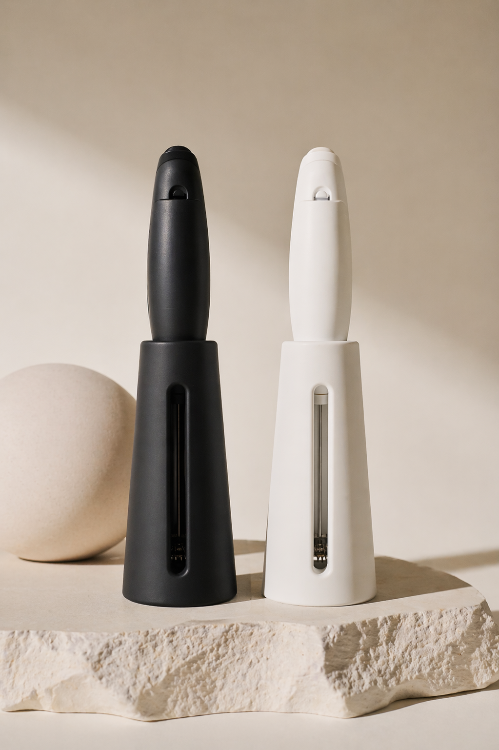Black and white NŌARA frother and silicone stand showing open back airflow design